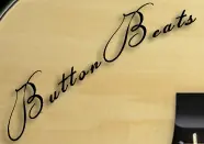 ButtonBass Player Acoustic Guitar logo